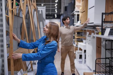 Erkek ve kadın modern mobilyalarla dolu şık bir mağazayı keşfediyorlar.