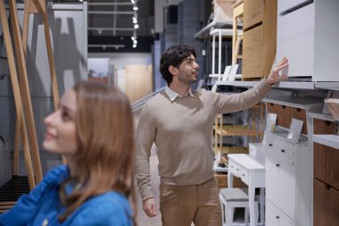 Erkek ve kadın modern mobilyalarla dolu şık bir mağazayı keşfediyorlar.