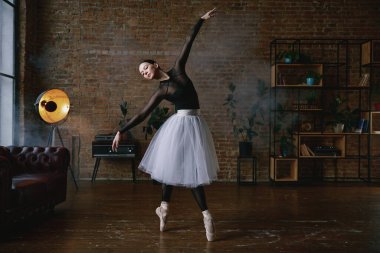 Yetenekli bir balerin modern dekor ve sıcak, davetkar ışıklandırmasıyla şık bir stüdyoda güzel bir performans sergiliyor.