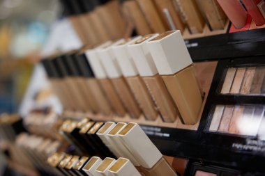 Çeşitli fondöten şişeleri düzgün bir şekilde dizilir ve kolay erişim ve görüntüleme için iyi düzenlenmiş bir rafa yerleştirilir.