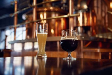 İki soğuk bardak bira cilalanmış ahşap bir bara yerleştirilir ve müşterilerin rahatlaması ve eğlenmesi için hoş bir ortam yaratır.