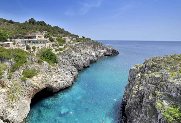 崖に囲まれたプーリアのアドリア海の湾のターコイズブルーの水と水泳 — ストック写真