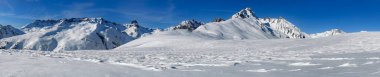 beautiful panoramic view on snowy mountain range  in French alps in Tarentaise under blue sky clipart