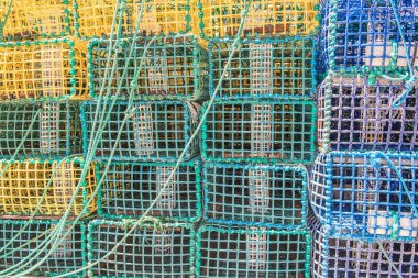 Portekiz 'de bir limana istiflenmiş yeşil, sarı ve mavi balıkçı tuzaklarının ön manzarası 