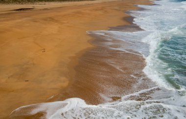  Portekiz 'in batı kıyısındaki bir kumsalda deniz köpüğü. Portekiz' in batı kıyısındaki bir plajda köpük birikintisi oluşturan dalgaların yüksek görüntüsü.