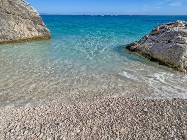 Sardinya-İtalya 'daki güzel Cala Goloritze plajı, kayalar arasında turkuaz deniz.  