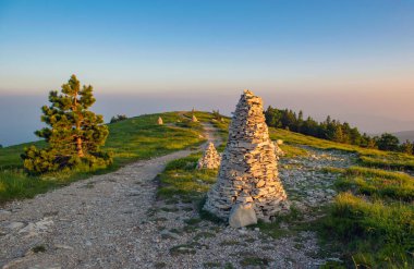 Fransa 'nın Vaucluse kentindeki Lure Dağı' nda gün batımında yolun kenarında bir dağ cairn 'i.