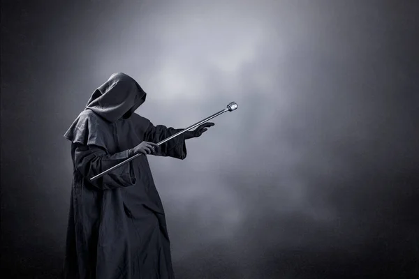 어두운 배경에 후드를 망토를 마법사와 지팡이를 마법사 — 스톡 사진