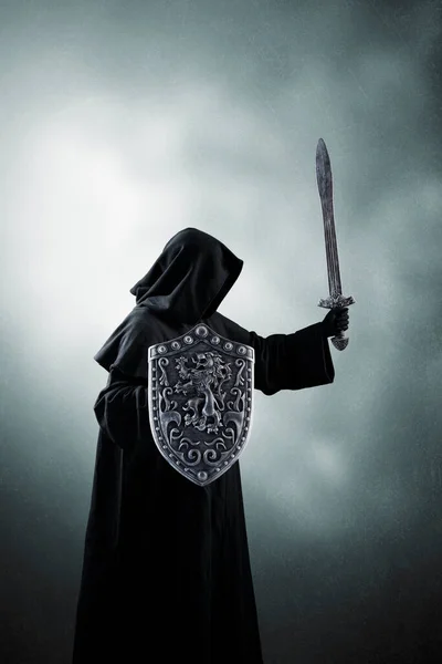 暗い霧の背景に剣と盾を持つダークナイト — ストック写真