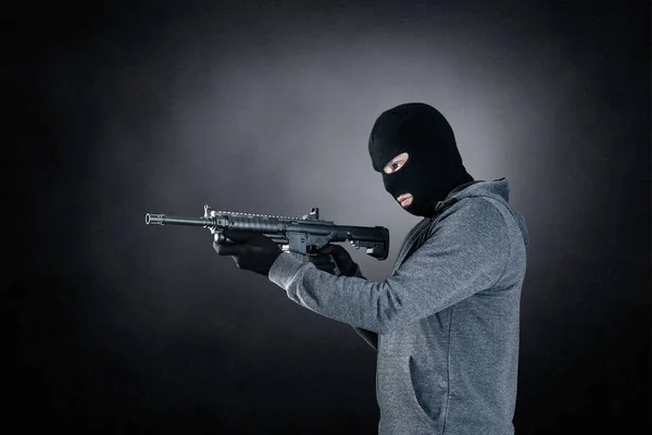 후드를 어두운 위에서 돌격소총을 — 스톡 사진