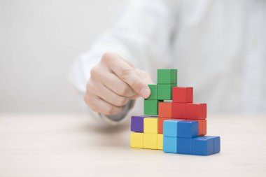 Renkli ahşap bloklar istifleme elini. İş geliştirme kavramı