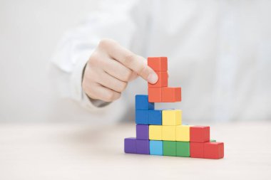 Renkli ahşap bloklar istifleme elini. İş geliştirme kavramı