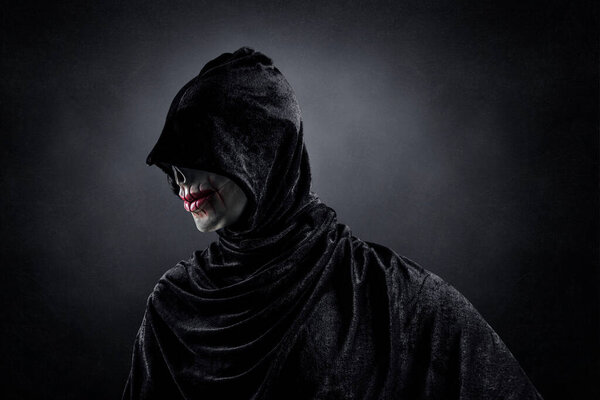 Страшная фигура с капюшоном в темноте