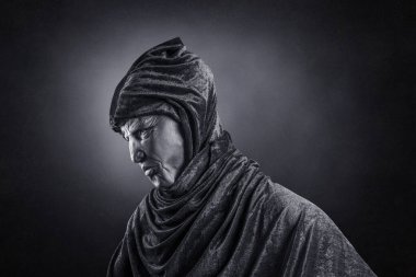 Karanlıkta kapüşonlu pelerinli korkunç bir figür.