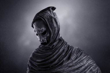 Pelerinli vampir karanlık sisli arka planda korkunç dişlerini gösteriyor.