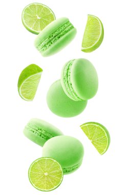 Macaroons and pieces of lime fruit levitation isolated on white background