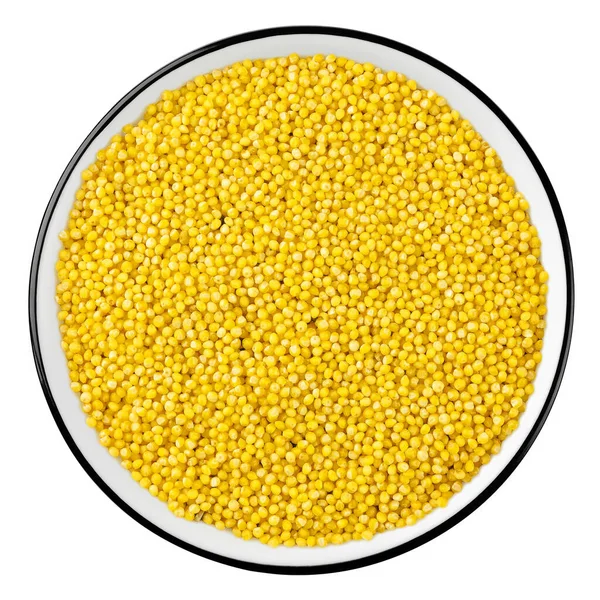 白い背景に隔離されたボウルの生の黄色いミレットの穀物のトップビュー ロイヤリティフリーのストック画像