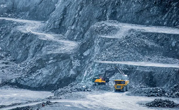 Stock image Excavator loading a dump truck in a multi-tiered diabase quarry in Parekklisia, Cyprus