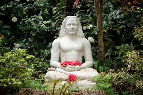 Meditation garden with sitting sculpture holding flowers