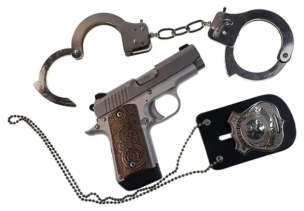 带手铐和警徽的9毫米银枪 免版税图库照片
