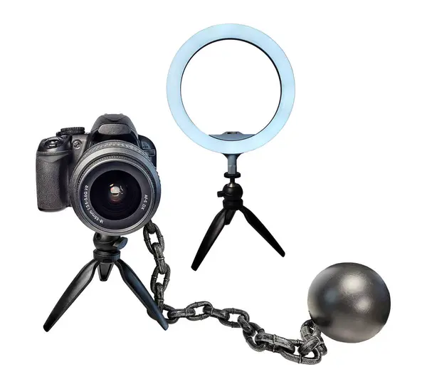 stock image A camera tripod stand holding a camera with a beauty light and ball and chain to show the need to always have good podcast content