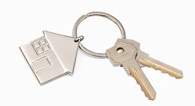 Gümüş ev anahtarlığı olan iki ev anahtarı.