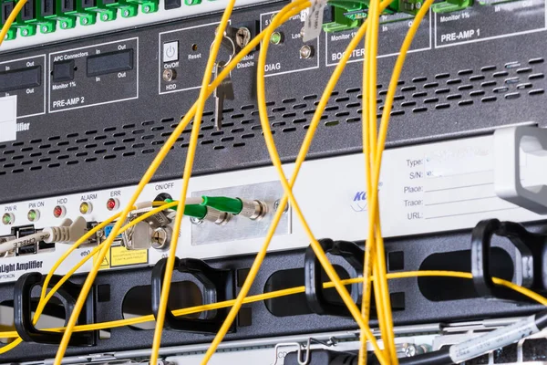 fiber optic cables plugged in network switch panels inside data center