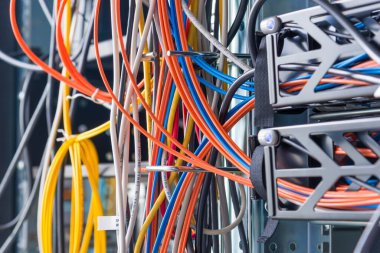 detail of large number of ethernet cables tied together connecting racks inside server room clipart