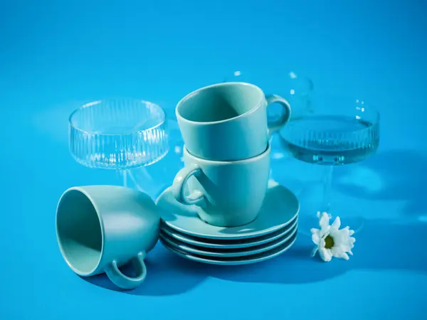 Tassen Und Gläser Auf Blauem Hintergrund lizenzfreie Stockfotos