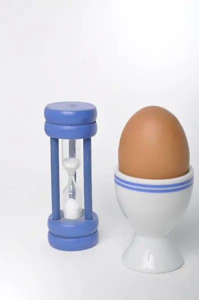Βραστό Αυγό Και Κλεψύδρα Λευκό Φόντο Εικόνα Αρχείου