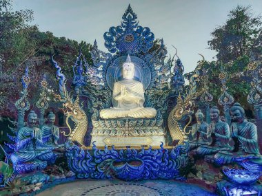 Gece Wat Rong Suea 'da ibadet eden keşişler ve Buda heykelleri. On mavi tapınak, Chiang Rai, Tayland