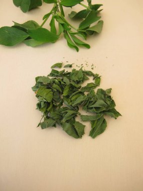 Alfalfa yaprağı çayı: ahşap bir tahtanın üzerinde kurumuş lucern yaprakları