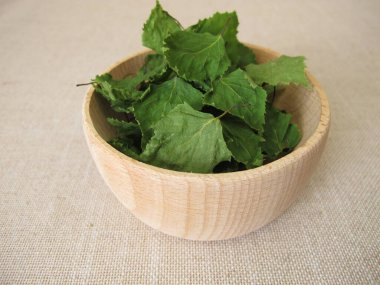 Kurumuş huş yaprağı yaprağı yaprağı çayı için ahşap bir kasede.