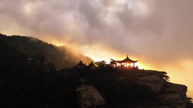 Gün batımında saat bulutlarının video klibi. Turistler Lushan Dağı, Çin 'deki uçurumun manzarasına hayran kaldılar.