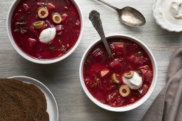 Two Bowls Chunky Borscht Soup Topped Green Olives Sour Cream — Stock Photo, Image