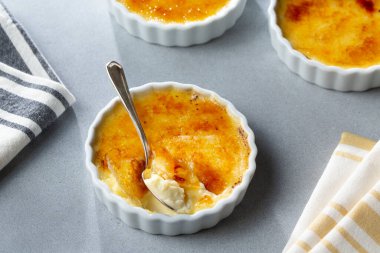 Cracked Sugar Creme Brulee Decadent Custard Dessert with spoon ready to share and eat  clipart