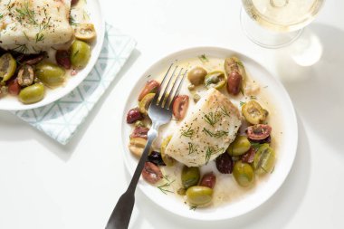 Parlak Yaz Bitkisi ve Zeytinbalığı filetosu iki tabak beyaz şaraplı