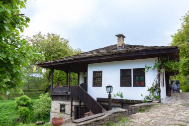 BOZENTSI, BULGARIA - 26 Mayıs 2023: Bulgaristan 'ın Gabrovo bölgesindeki köyün mimari-tarihi rezervindeki eski evlerin bahar manzarası