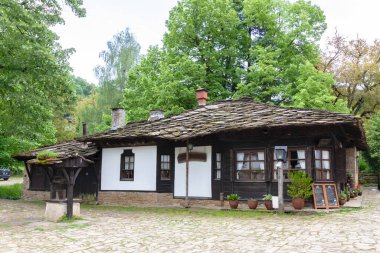 BOZENTSI, BULGARIA - 26 Mayıs 2023: Bulgaristan 'ın Gabrovo bölgesindeki köyün mimari-tarihi rezervindeki eski evlerin bahar manzarası