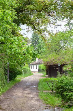 BOZENTSI, BULGARIA - 26 Mayıs 2023: Bulgaristan 'ın Gabrovo bölgesindeki köyün mimari-tarihi rezervindeki eski evlerin bahar manzarası