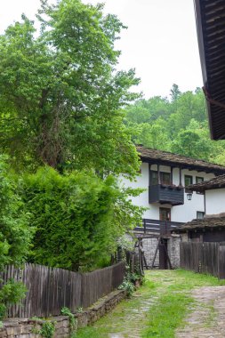 BOZENTSI, BULGARIA - 26 Mayıs 2023: Bulgaristan 'ın Gabrovo bölgesindeki köyün mimari-tarihi rezervindeki eski evlerin bahar manzarası