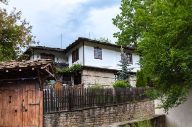 BOZENTSI, BULGARIA - 26 Mayıs 2023: Bulgaristan 'ın Gabrovo bölgesindeki köyün mimari-tarihi rezervindeki eski evlerin bahar manzarası