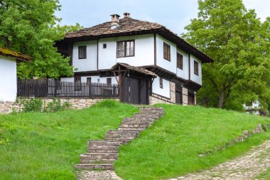 BOZENTSI, BULGARIA - 26 Mayıs 2023: Bulgaristan 'ın Gabrovo bölgesindeki köyün mimari-tarihi rezervindeki eski evlerin bahar manzarası