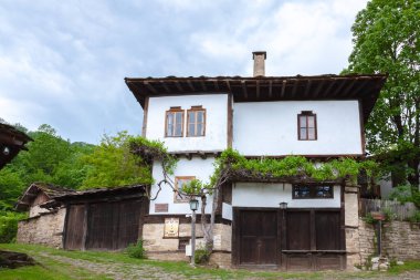 BOZENTSI, BULGARIA - 26 Mayıs 2023: Bulgaristan 'ın Gabrovo bölgesindeki köyün mimari-tarihi rezervindeki eski evlerin bahar manzarası