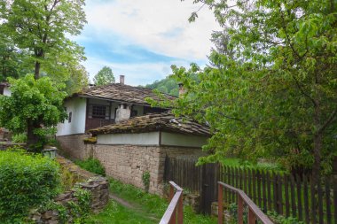 BOZENTSI, BULGARIA - 26 Mayıs 2023: Bulgaristan 'ın Gabrovo bölgesindeki köyün mimari-tarihi rezervindeki eski evlerin bahar manzarası