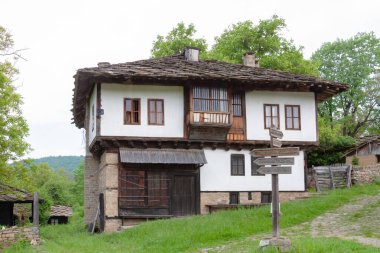 BOZENTSI, BULGARIA - 26 Mayıs 2023: Bulgaristan 'ın Gabrovo bölgesindeki köyün mimari-tarihi rezervindeki eski evlerin bahar manzarası