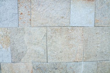 Yatay olarak düzenlenmiş taşların duvar kaplaması. Sığ alan derinliğine sahip seçici odak.