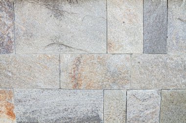 Yatay olarak düzenlenmiş taşların duvar kaplaması. Sığ alan derinliğine sahip seçici odak.