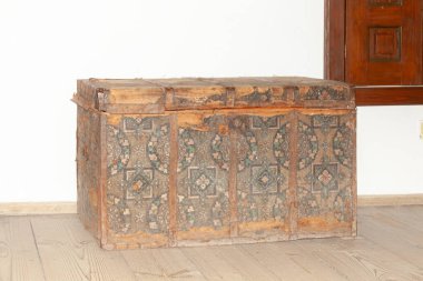 Kırsal tarzda süslerle süslenmiş eski ahşap elbise sandığı. Sığ alan derinliğine sahip seçici odak.