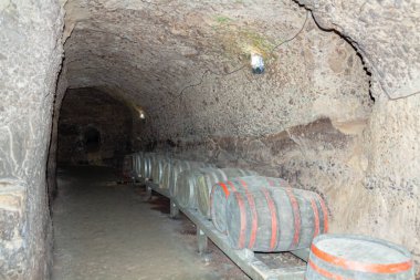 Bir yeraltı galerisinde yıllanmış şarap fıçıları. Sığ alan derinliğine sahip seçici odak.